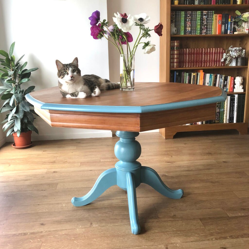 Une table en merisier, dont le pied a été peint en bleu